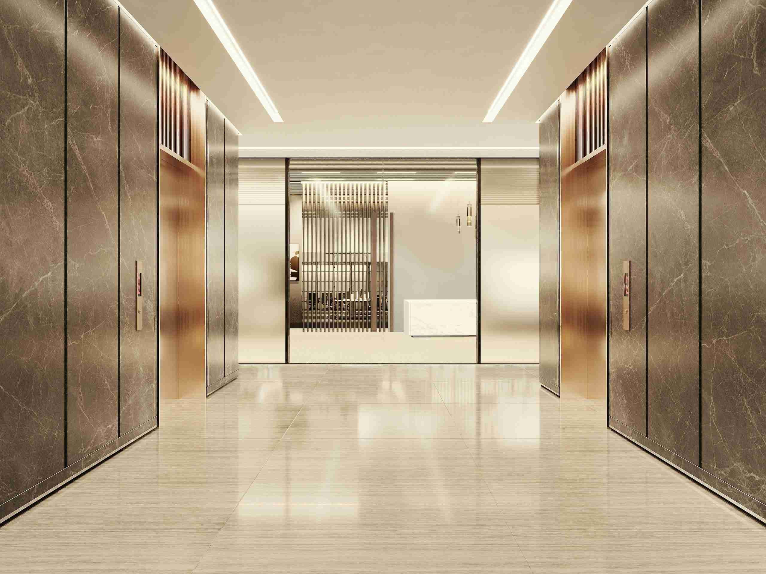 A modern elevator lobby with four closed elevators, marble floors, and metallic wall panels; in the background, glass doors reveal a minimalistic reception area with a marble desk.